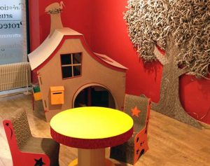 Espace enfant : cabane, arbre, table et chaises en carton